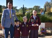 Retired Australian Army Corporal Nathan Flanagan with his children Halle, Sophia, and Amalia at Cowra's Australian War Cemetery.