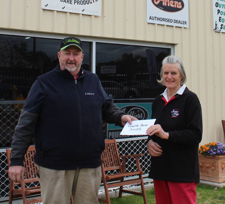 Danny Quinn presents Cowra Show Society President Anne Jeffery with a cheque. COPES will be the name sponsor of the Cowra Woodchop Competition.