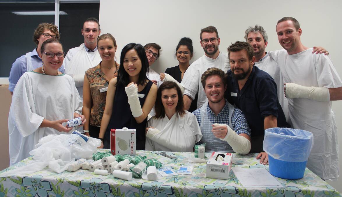 Cowra's recent medical students practicing placing casts on one another.